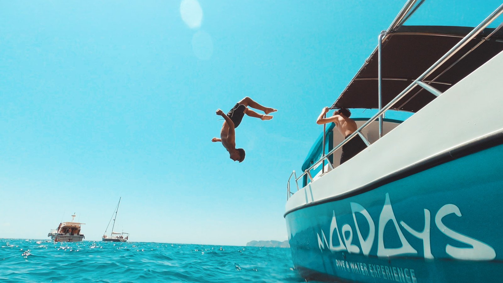 Acrobata haciendo backflip desde barco al mar en Indomove Academy