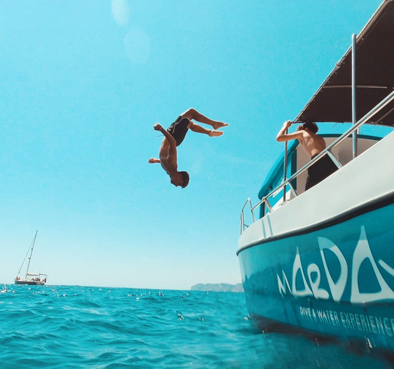 Acrobata haciendo backflip desde barco al mar en Indomove Academy